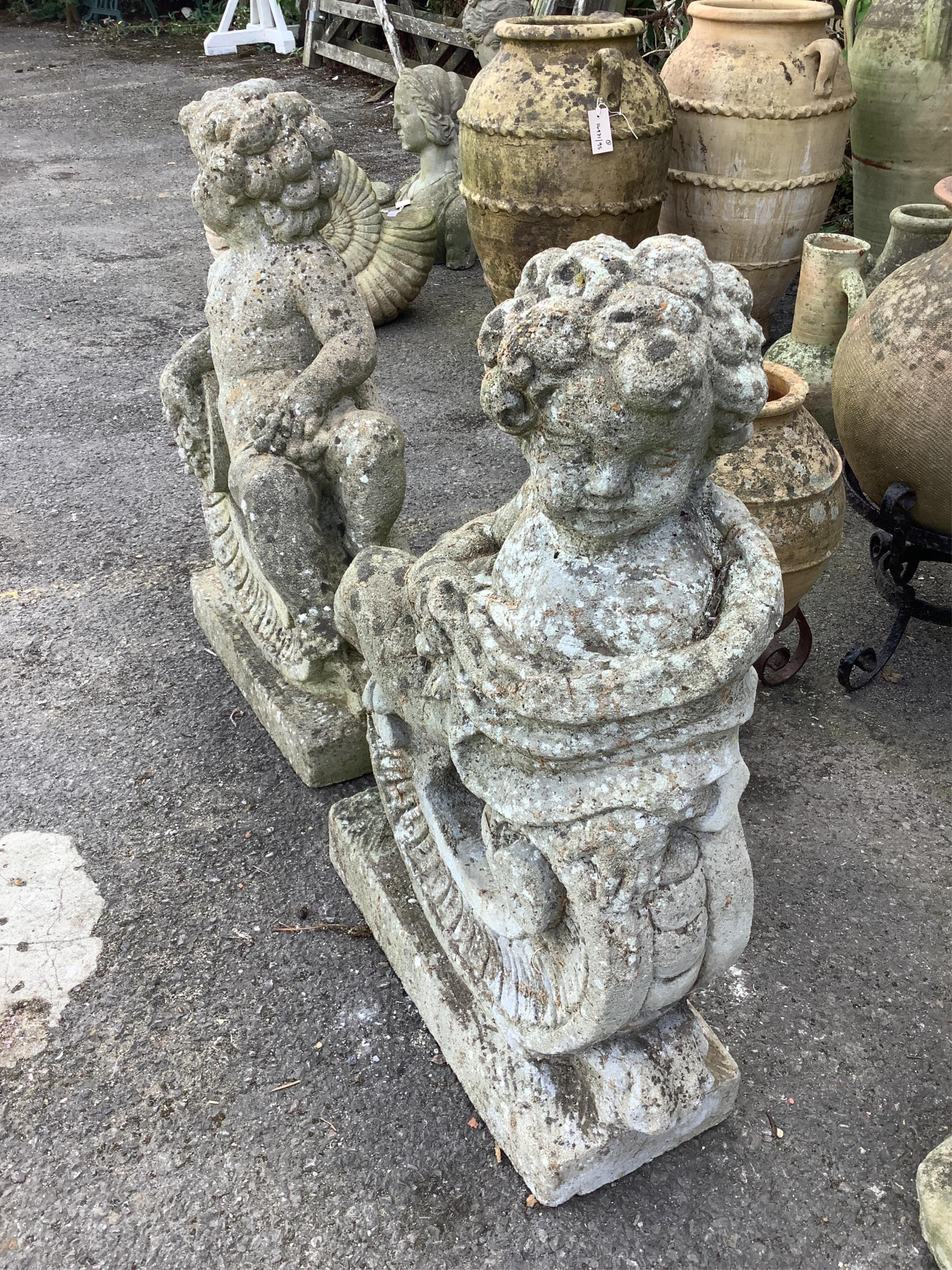 A pair of reconstituted stone putti and scroll garden ornaments, height 68cm. Condition - poor to fair